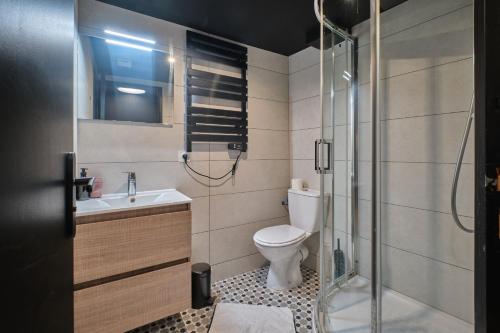 a bathroom with a toilet and a glass shower at L'atypique Chez Les Amoureux in Le Touvet
