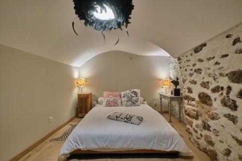 a bedroom with a bed with a chandelier above it at L'atypique Chez Les Amoureux in Le Touvet