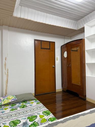 a bedroom with a bed and a wooden door at Baloy Enyo-Noning in Baao