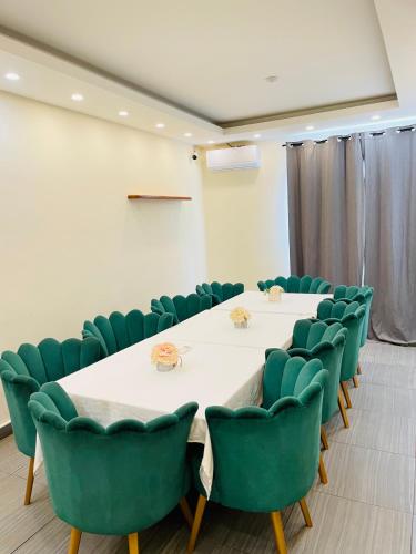 a conference room with a table and green chairs at CINCINNATI HOTEL YAOUNDE in Yaoundé