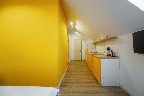 a room with a yellow wall and a kitchen at BonApart Delux in Lviv