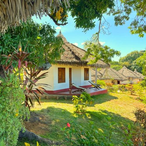 a cottage in the middle of a garden at WINGS HOTELS in Nosy Be