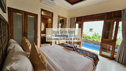 1 dormitorio con 1 cama y vistas a la piscina en Jepara Garden Resort, en Jepara