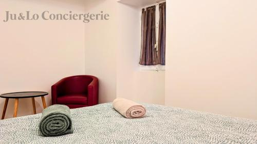 une chambre avec un lit et une chaise rouge dans l'établissement Maison Redonnaise Centre Ville, à Redon