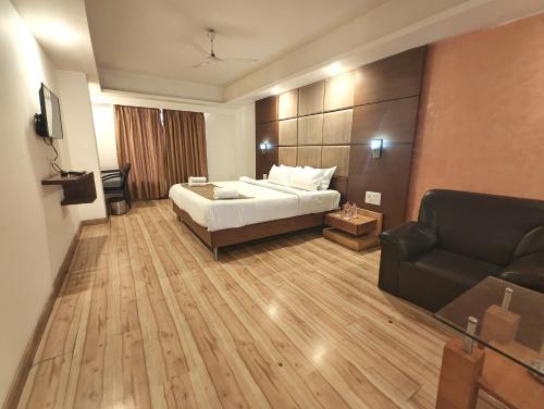 a hotel room with a bed and a couch at The Sky Comfort, Ahmedabad in Ahmedabad