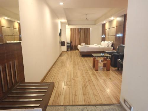 a hotel room with a bed and a living room at The Sky Comfort, Ahmedabad in Ahmedabad