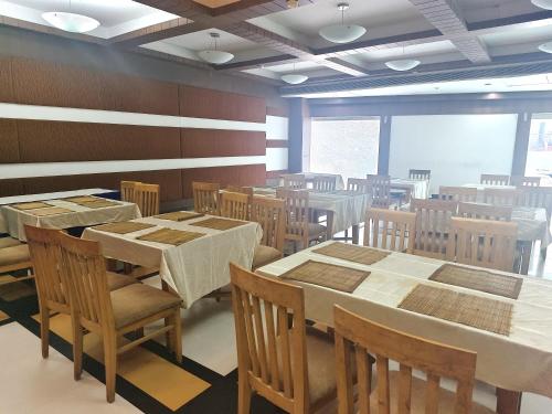 an empty dining room with tables and chairs at The Sky Comfort, Ahmedabad in Ahmedabad