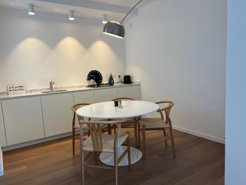 a kitchen with a white table and chairs at Casa MauRo in Senigallia