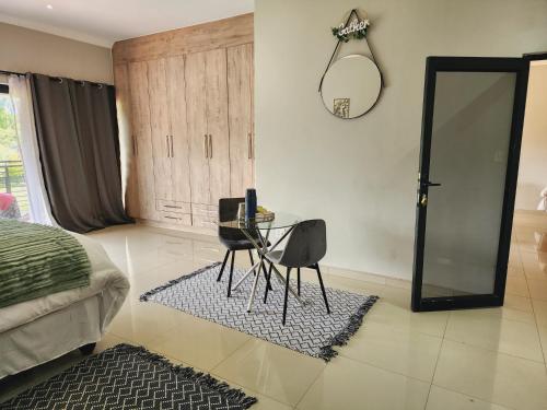 a bedroom with a table and a mirror and a bed at Eastern Road Executive Suites in Harare