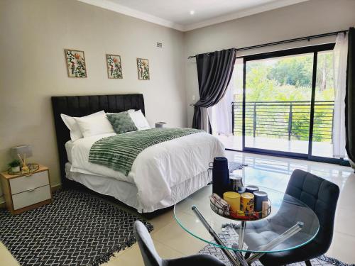 a bedroom with a bed and a chair and a window at Eastern Road Executive Suites in Harare