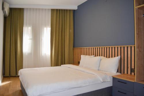a bedroom with a large white bed and a window at Loca Centre Suites in Bodrum City