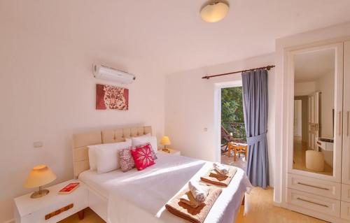 a bedroom with a white bed with red pillows at Villa Basil in Kaş