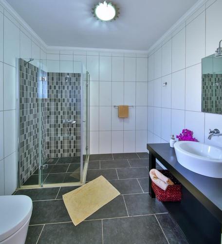 a bathroom with a shower and a sink and a toilet at Villa Basil in Kaş