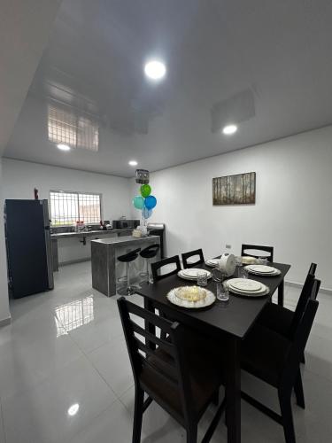 a dining room with a table and chairs and a kitchen at Premium in Comayagua