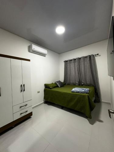a bedroom with a green bed and a window at Premium in Comayagua