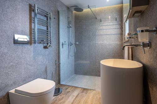 a bathroom with a shower and a toilet and a sink at Old Theatre Suites - Maddalena in Valletta