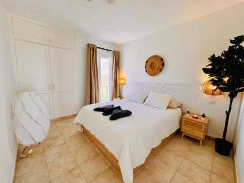 a bedroom with a white bed with a plant on it at Little Gem in Matagorda