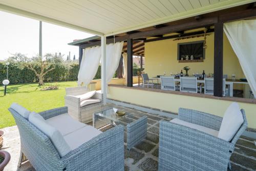 a patio with two chairs and a table with a dining room at Casale Fattoria Benaris With Private Pool - Marsiliana in Marsiliana