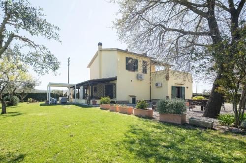 a house with a lawn in front of it at Casale Fattoria Benaris With Private Pool - Marsiliana in Marsiliana