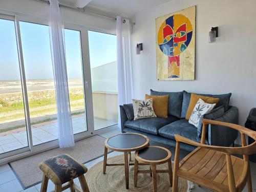 a living room with a couch and chairs and a table at Relais des îles Saint Marcouf in Saint-Marcouf