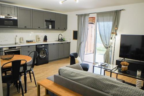 une cuisine et un salon avec un canapé et une table dans l'établissement Tout confort à Viggianello, à Viggianello