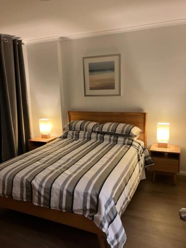 a bedroom with a bed with two lamps on tables at Great Place in Perth CBD - 2 bedrooms - parking included in Perth