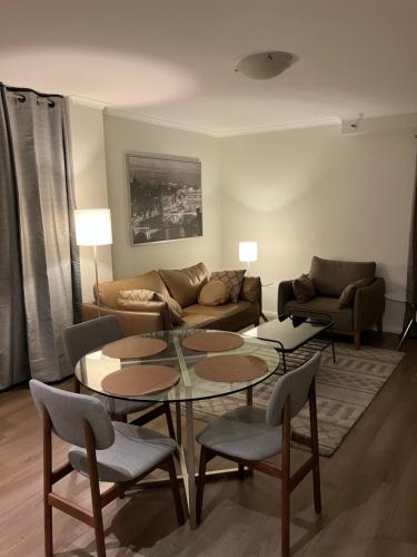 a living room with a couch and a table and chairs at Great Place in Perth CBD - 2 bedrooms - parking included in Perth