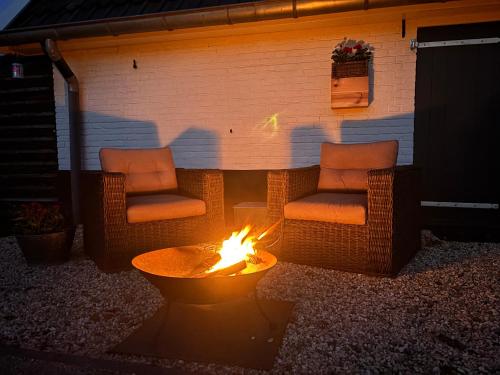 two chairs and a fire pit in a backyard at Mijn Buitenhuis in Elspeet