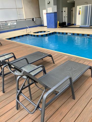 a swimming pool with two chairs in front of it at Great Place in Perth CBD - 2 bedrooms - parking included in Perth