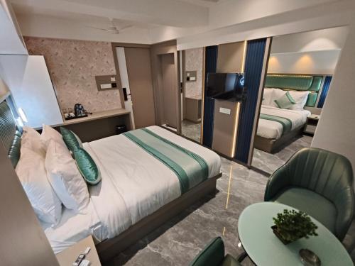 a hotel room with a bed and a desk and a chair at Hotel Prime Suites Airoli in Navi Mumbai