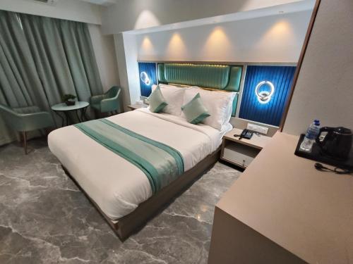 a hotel room with a large bed and chairs at Hotel Prime Suites Airoli in Navi Mumbai