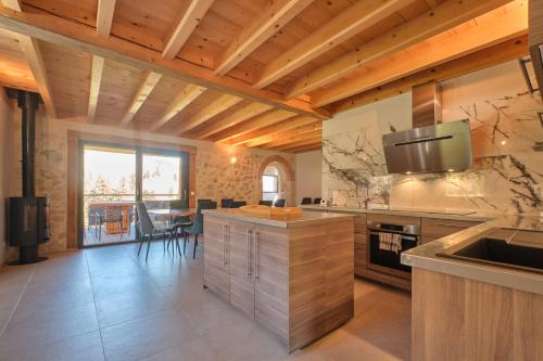 Il comprend une cuisine dotée de plafonds en bois et une salle à manger. dans l'établissement Les 3 Som, à Saint-Pierre-de-Chartreuse