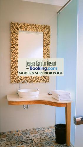 a mirror on a wall above a wooden table at Jepara Garden Resort in Jepara