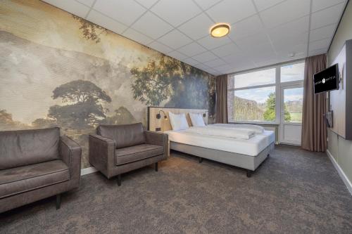 a bedroom with a bed and two chairs at Fletcher Hotel Restaurant Bon Repos in Noorbeek