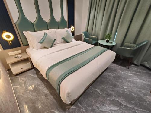 a bedroom with a large bed with a green headboard at Hotel Prime Suites Airoli in Navi Mumbai