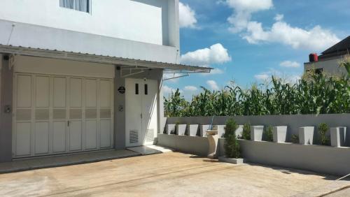 a house with a white garage and a fence at Alia Corner Homestay in Mandiraja