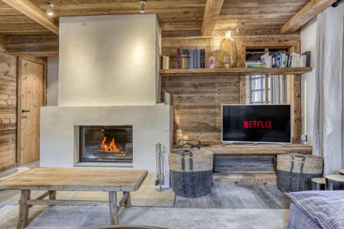 un salon avec une cheminée et une télévision dans l'établissement Flocon, à Megève