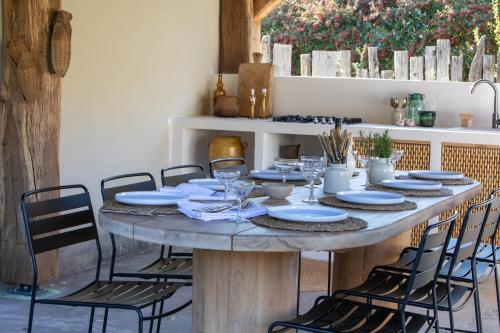 a table with chairs and plates on top of it at La Grange de Fer - Maison de caractère piscine privée in Saint-Ferréol-Trente-Pas