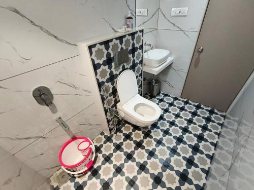 a bathroom with a white toilet and a sink at Hotel Prime Suites Airoli in Navi Mumbai