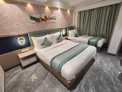 a hotel room with two beds in it at Hotel Prime Suites Airoli in Navi Mumbai