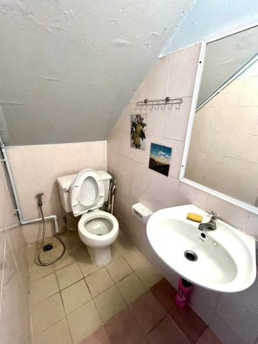 a bathroom with a toilet and a sink at FirstFloorDormA in Ban Nong Khwang Tawan