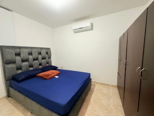 a small bedroom with a bed with a blue bedspread at Hermoso apartamento 3 habitaciones in Cúcuta