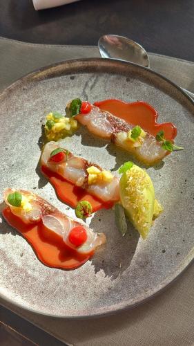 a plate of food with peppers on a table at Hotel restaurant Spa Disini Montpellier Est, The Originals Relais in Castries