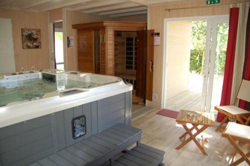 une grande baignoire jacuzzi dans une chambre dans l'établissement Camping maeva Escapades Les Hauts de Port, à Penvénan