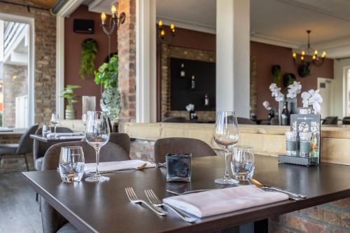 a table in a restaurant with wine glasses on it at Fletcher Hotel Restaurant Bon Repos in Noorbeek