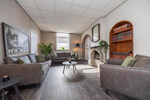 a living room with couches and a fireplace at Fletcher Hotel Restaurant Bon Repos in Noorbeek
