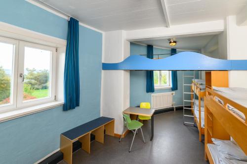 a room with a bunk bed and a desk at Jugendherberge Otto-Moericke-Turm in Konstanz