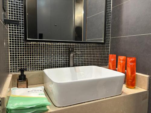 a white sink in a bathroom with a mirror at Wesu Light Luxury Apartment Shenzhen Nantou Gucheng Branch in Shenzhen