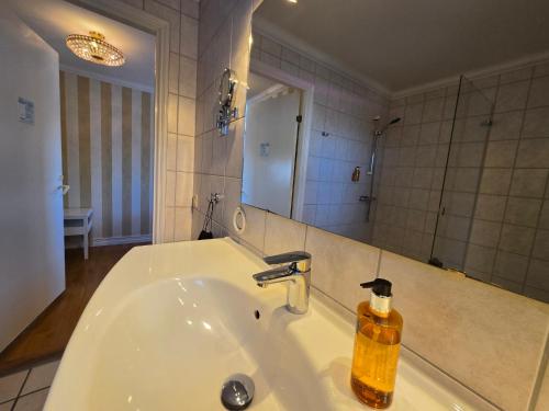 a bathroom with a sink with a soap dispenser on it at Vänerport Lakefront Hotell in Mariestad