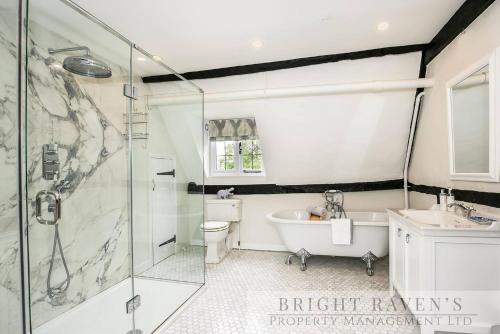 a bathroom with a shower and a tub and a sink at Old Manor House, an idyllic country house in Shabbington
